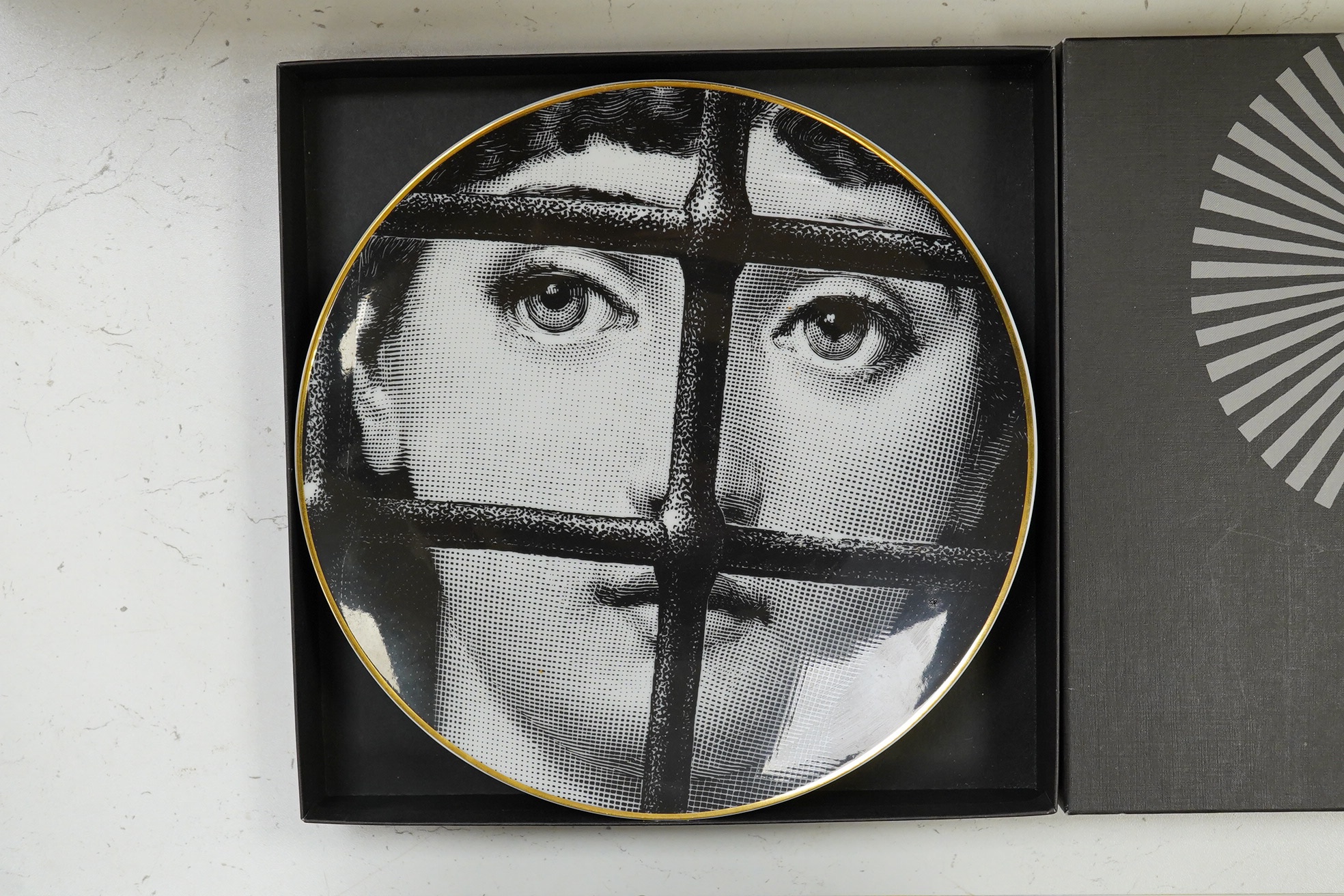 A boxed Rosenthal Fornasetti plate, 23.5cm in diameter. Condition - good